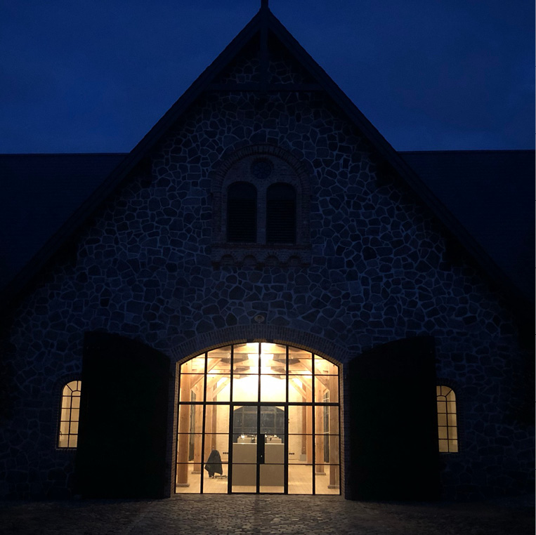 Barn conversion with bronze screen at nighttime