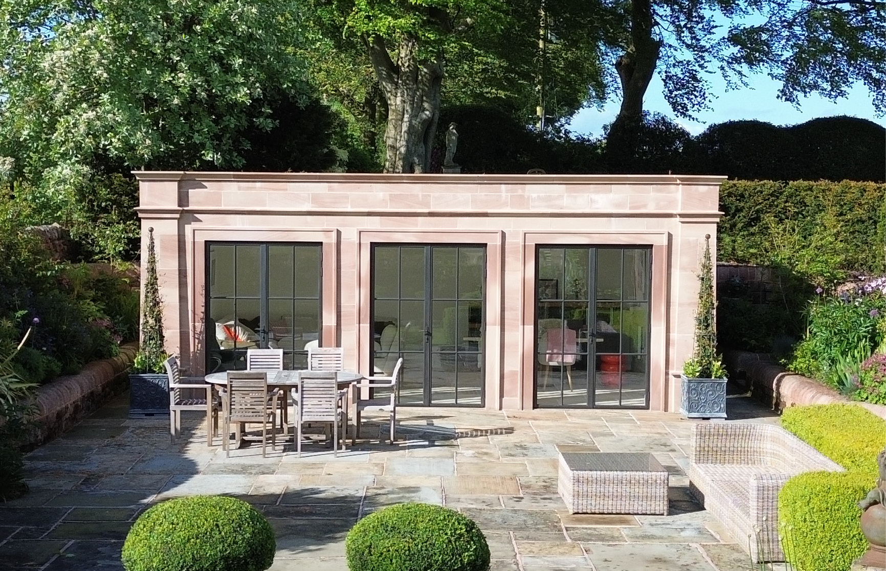 Freestanding garden room with bronze doors and screens
