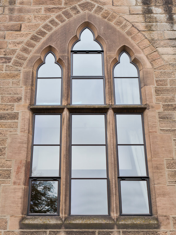 stone set metal curved window with horizontal transoms